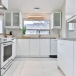 Modern kitchen with white cabinets and stainless steel appliances in Manhattan.