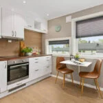 Modern kitchen with white cabinets and wooden countertops in Manhattan.