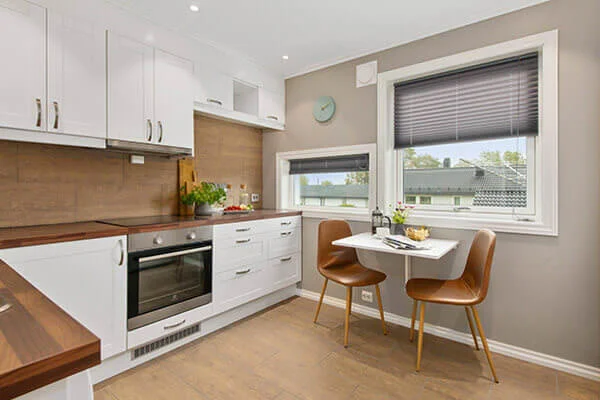 Modern kitchen with white cabinets and wooden countertops in Manhattan.