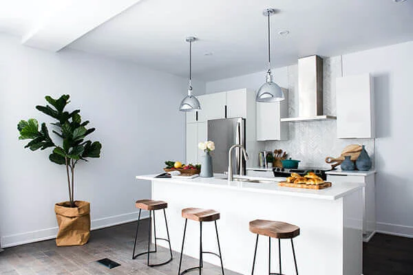 Modern kitchen with island, stools, and stainless steel appliances in Manhattan.