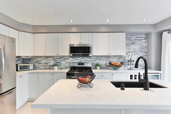 Modern kitchen with white cabinets and stainless steel appliances in Manhattan.